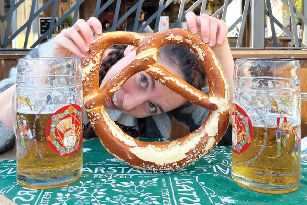 Cara with a large pretzel and beers.