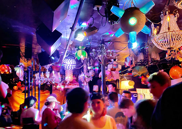 Colorful lamps light up a dance floor filled with people.