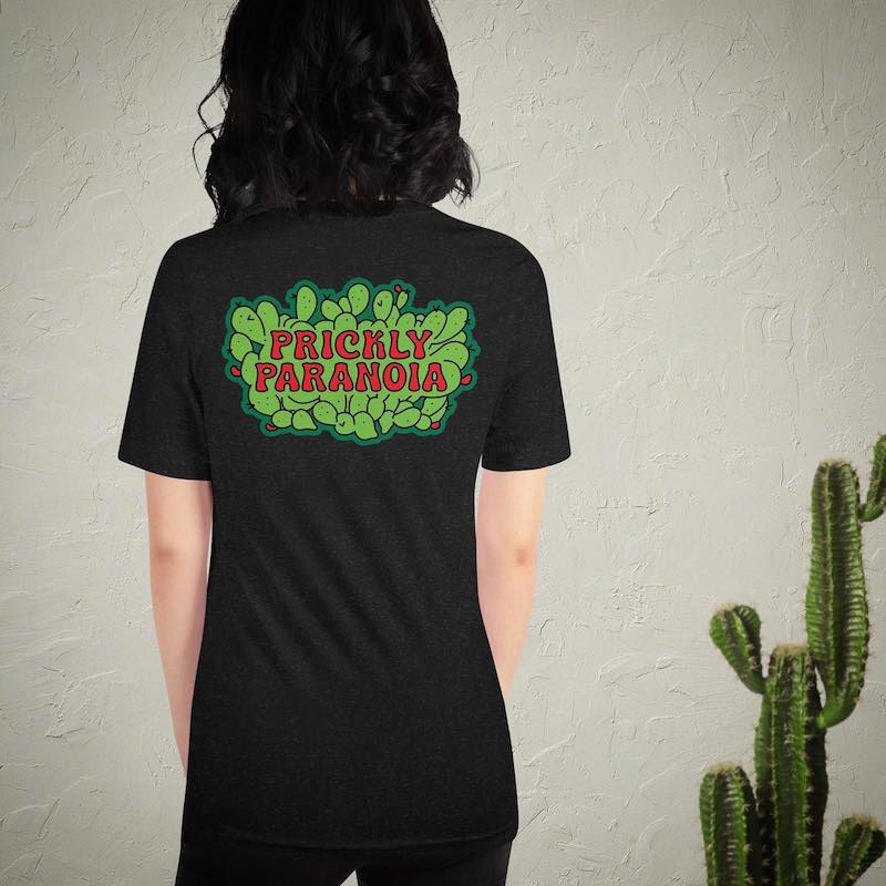 A woman wearing a black t-shirt with a colorful cactus logo.