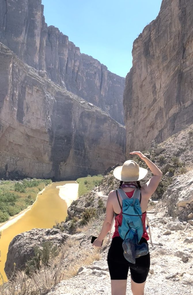 Cara hiking with the sun overhead.