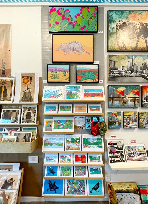 Wall of colorful art prints and paintings.