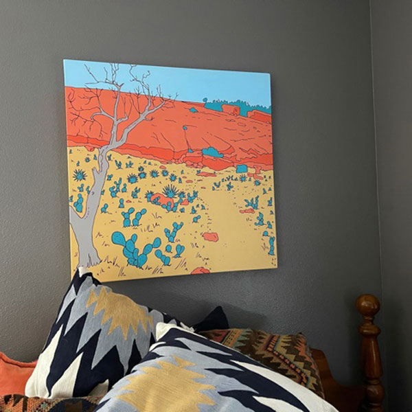 Bright painting hanging on grey wall above pillows.
